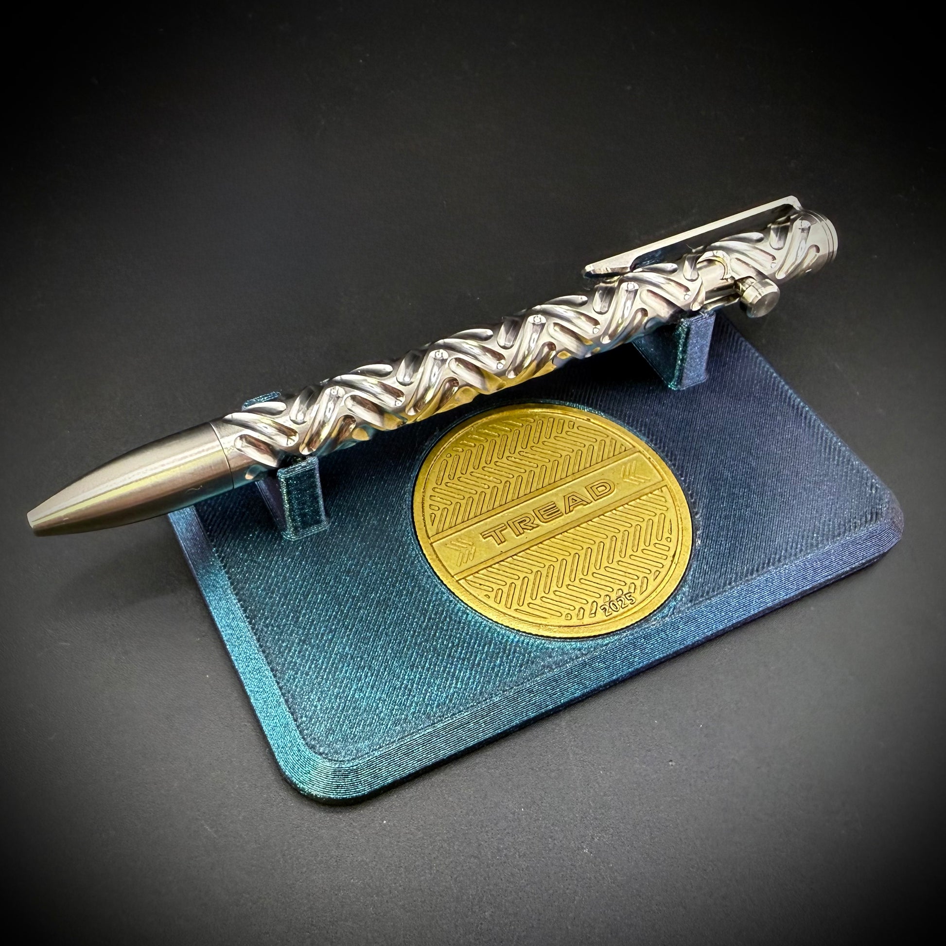 Silver pen with gold emblem on a dark background